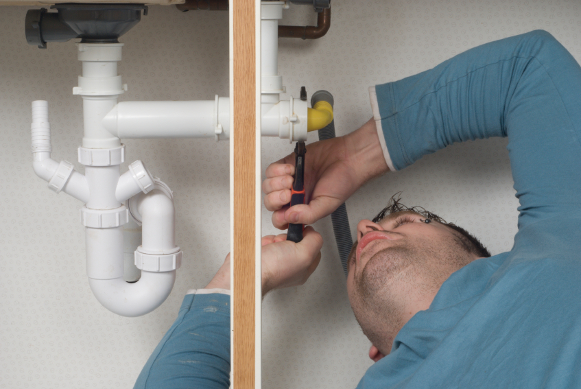Real Plumber at work under a sink